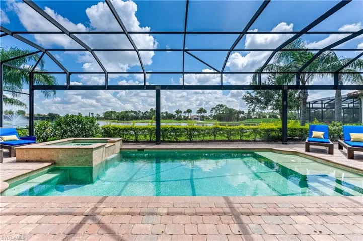 View of pool with glass enclosure, a sunroom, a pool with connected hot tub, and a patio