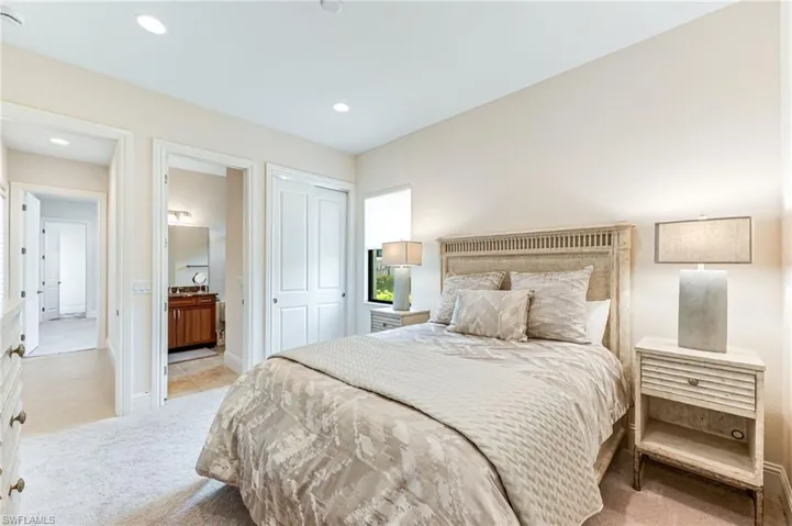 Bedroom with light colored carpet, a closet, recessed lighting, light tile patterned floors, and ensuite bathroom