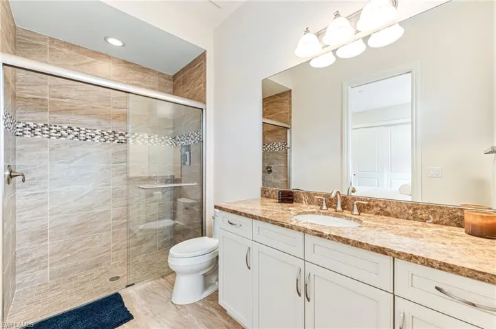 Full bath featuring vanity, a shower stall, and recessed lighting
