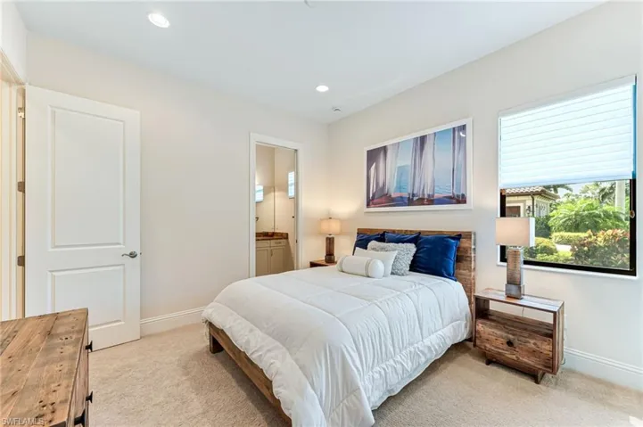Bedroom featuring light carpet, recessed lighting, and ensuite bathroom