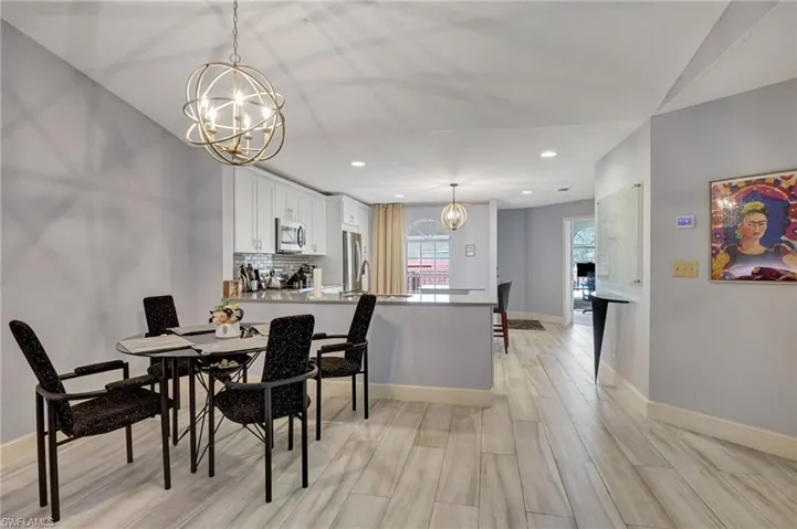 Dining area featuring, chandelier and wood look porcelain tile flooring