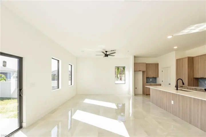 Unfurnished living room with ceiling fan and recessed lighting