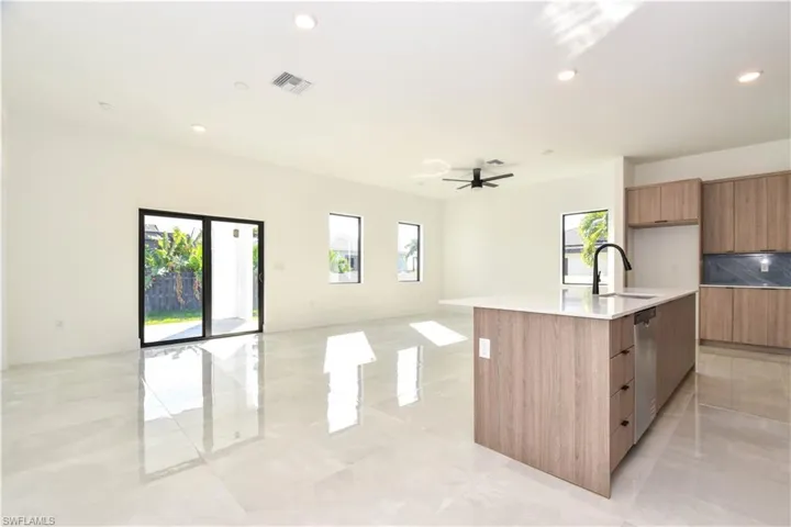 Kitchen featuring modern cabinets, an island with sink, plenty of natural light, and recessed lighting