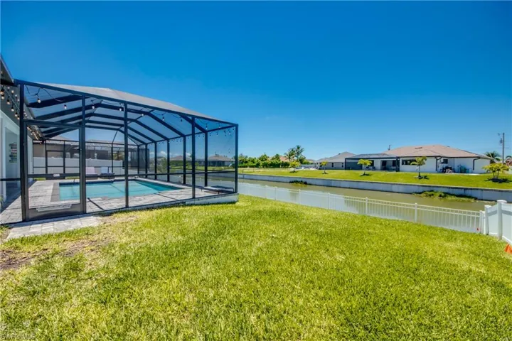 View of yard with a water view, a residential view, and glass enclosure