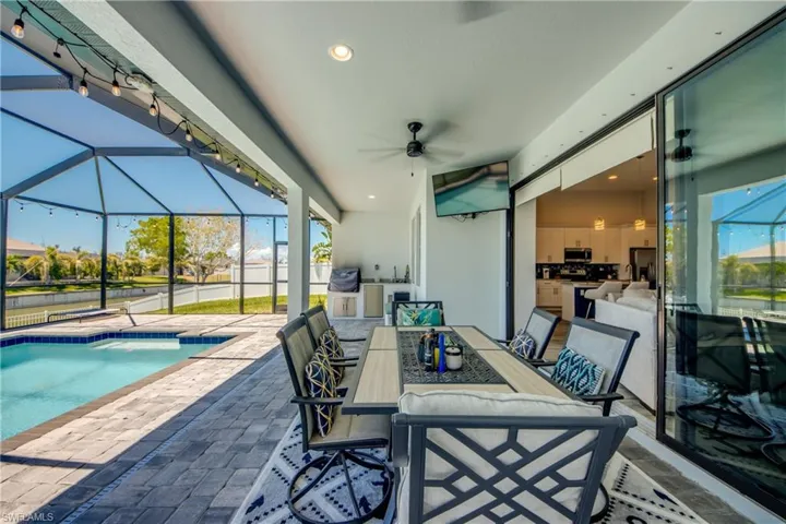 View of patio / terrace featuring area for grilling, ceiling fan, glass enclosure, and outdoor dining space