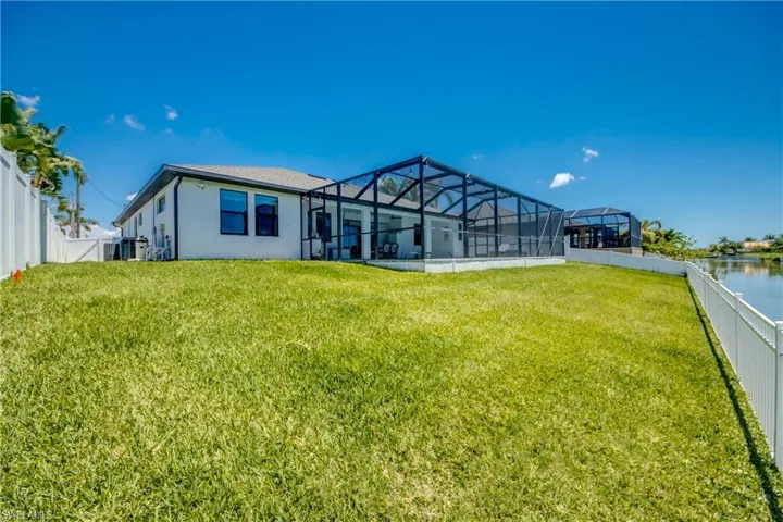 Back of house featuring glass enclosure and stucco siding