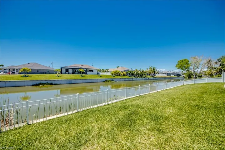 Water view with a fenced backyard and nearby suburban area