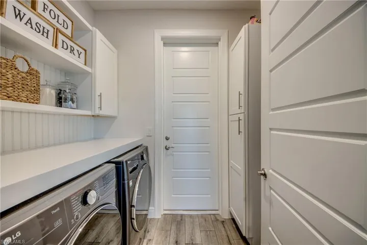 Laundry room featuring cabinet space, separate washer and dryer, and light wood-type flooring