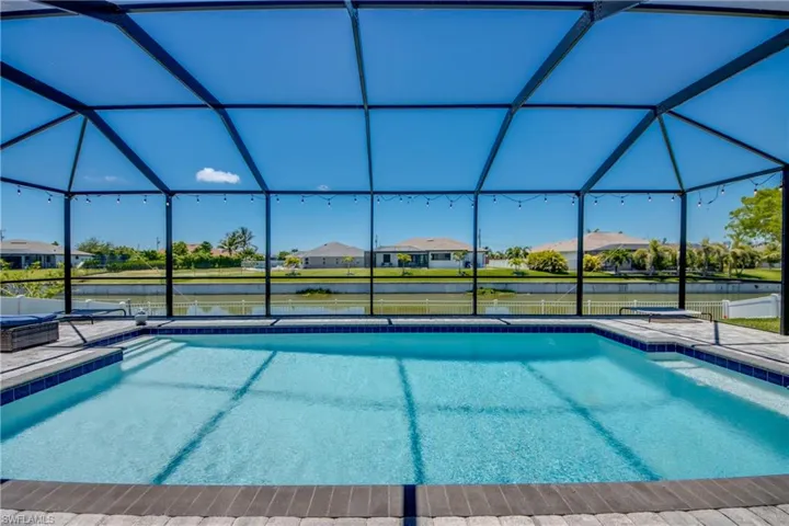 Outdoor pool featuring a water view, a lanai, a patio area, and a residential view