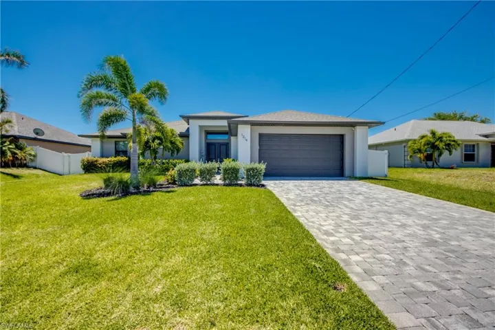 View of front of home featuring decorative driveway, an attached garage, and stucco siding