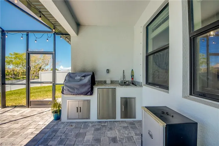 View of patio / terrace with an outdoor kitchen, area for grilling, and a sink