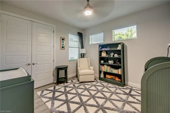 Sitting room with ceiling fan, baseboards, and light wood-type flooring