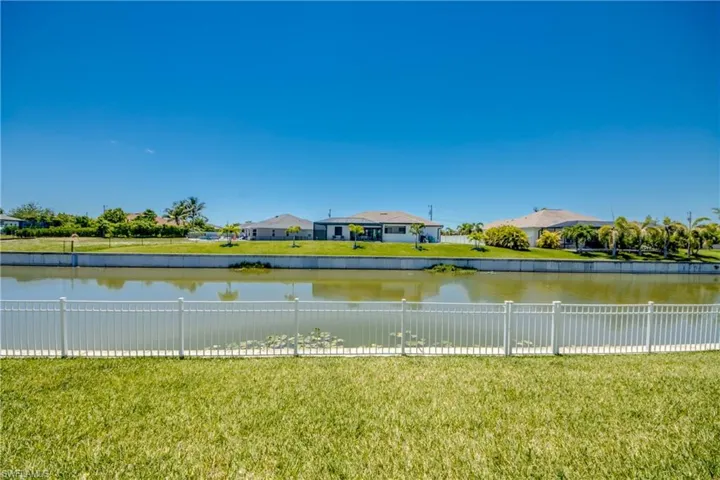 Water view with a fenced backyard and nearby suburban area