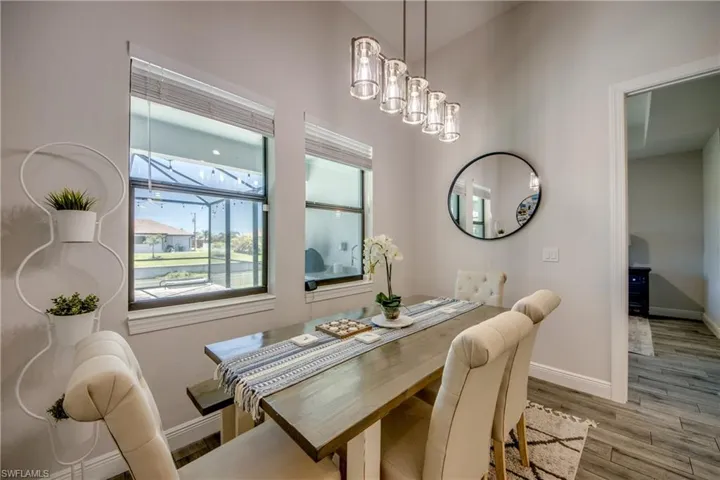 Dining space featuring baseboards, wood finished floors, and a chandelier