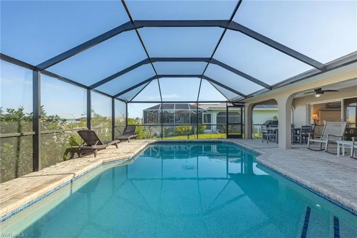 View of swimming pool featuring ceiling fan, a lanai, and a patio area