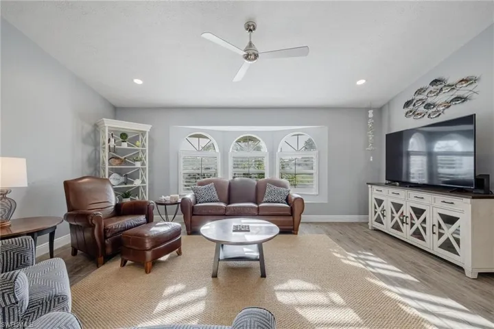 Living room with light wood-type flooring and ceiling fan