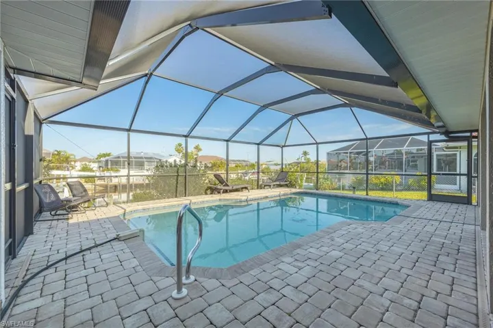 View of swimming pool with a patio and glass enclosure