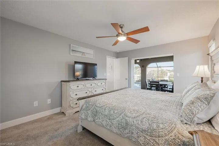 Bedroom with ceiling fan and light carpet