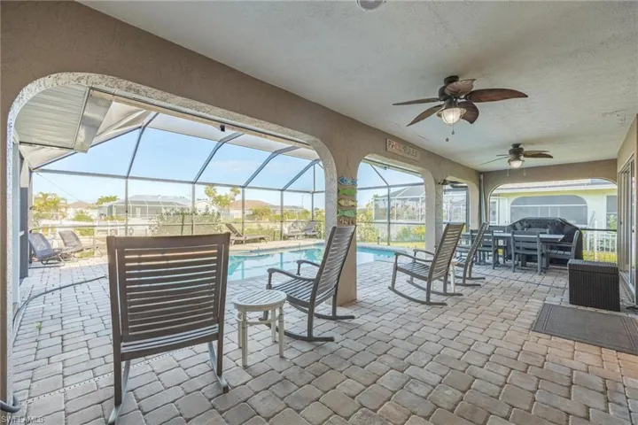 View of patio / terrace featuring glass enclosure and ceiling fan