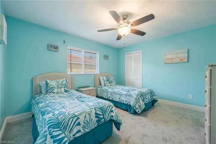 Bedroom with ceiling fan, a closet, and carpet