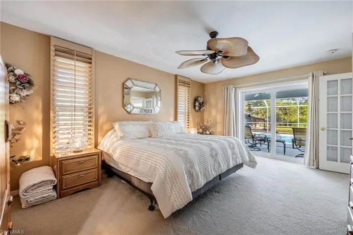 Carpeted bedroom featuring access to exterior and a ceiling fan