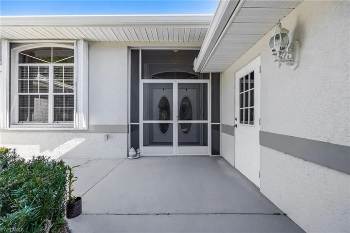Doorway to property featuring french doors and stucco siding