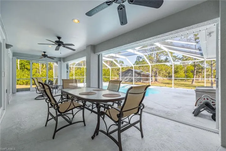 View of patio with outdoor dining space, a lanai, an outdoor pool, and ceiling fan