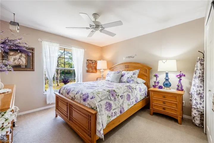 Bedroom featuring ceiling fan, baseboards, and light colored carpet