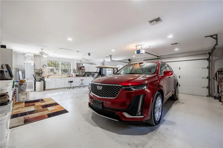 Garage with recessed lighting, ceiling fan, visible vents, and a garage door opener