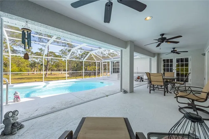 Outdoor pool with a lanai, ceiling fan, and a patio