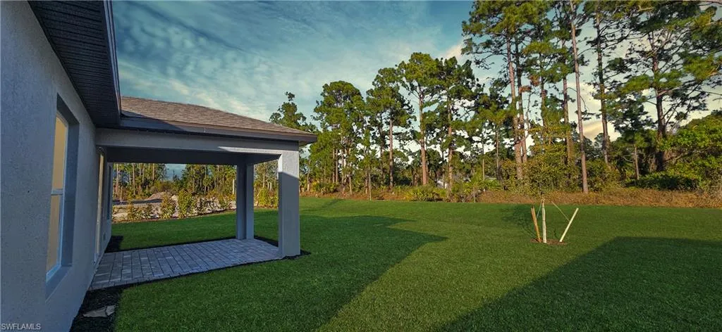 View of green lawn featuring a patio
