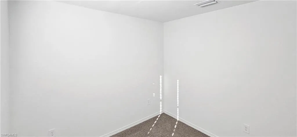 Unfurnished bedroom featuring dark carpet and a closet