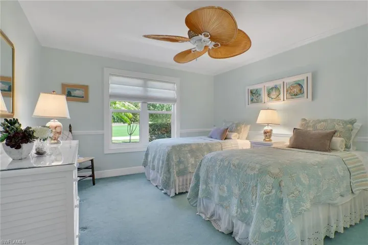 Bedroom featuring carpet floors, crown molding, and a ceiling fan