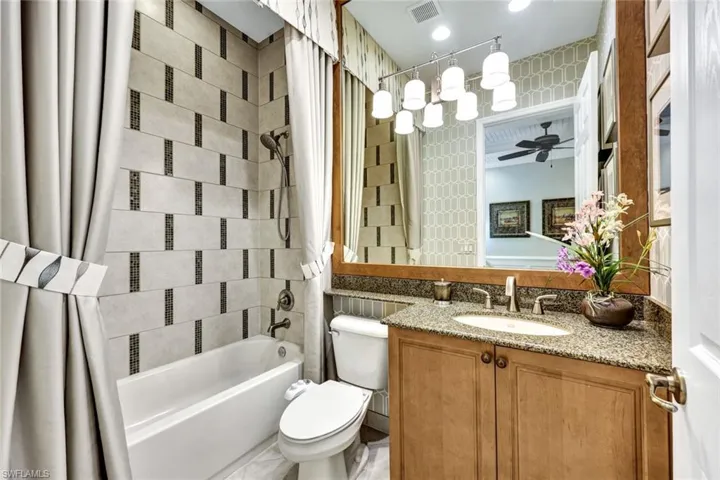 Bedroom 2 ensuite bath featuring vanity, toilet and shower/bath combo with custom shower curtain