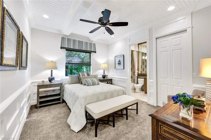Bedroom 2 featuring designer furnishings, new carpet, crown molding, ensuite bath, ceiling fan, and beam ceiling