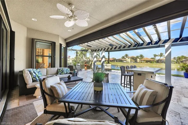 Lanai with premium water view, panoramic screened enclosure, pergola, built-in hot tub, outdoor kitchen, bar and covered living area