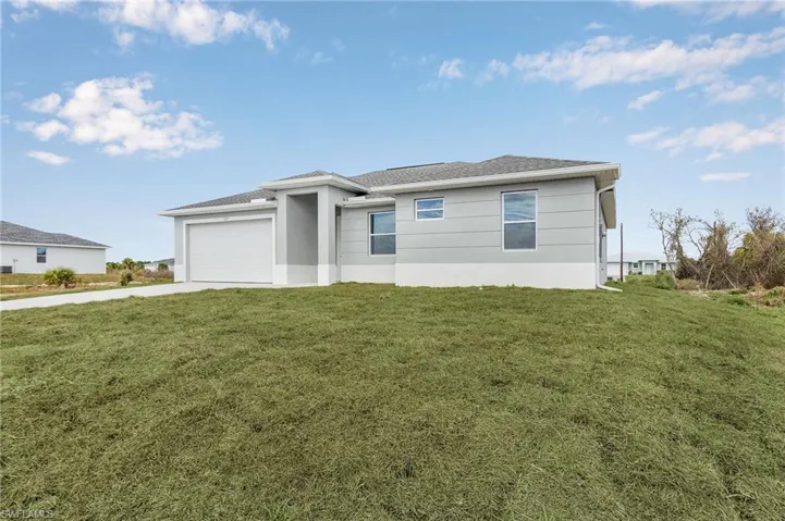 View of front of home featuring a garage and a front lawn