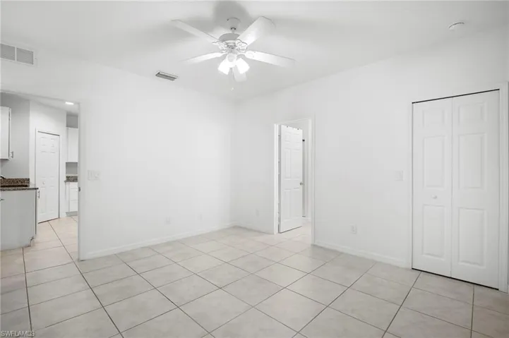 Unfurnished bedroom with light tile patterned floors, ceiling fan, and a closet