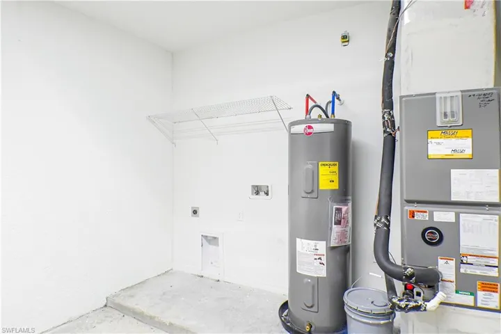 Utility room featuring water heater and heating unit