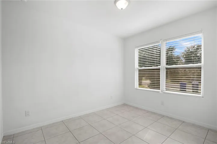 Spare room with baseboards and light tile patterned floors