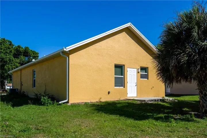 Back of property with stucco siding, a yard, and a patio area