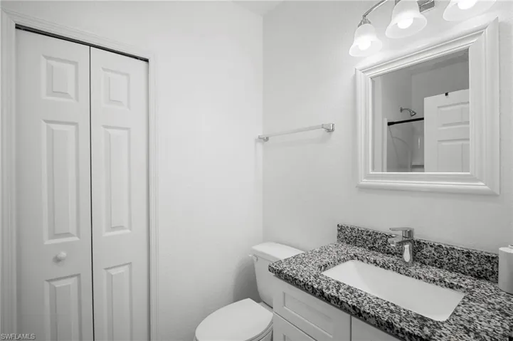 Bathroom with vanity, a closet, a shower, and a textured wall