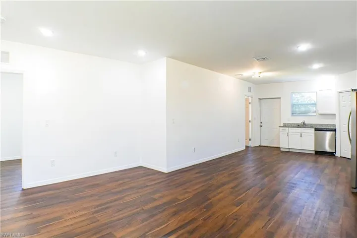 Unfurnished living room featuring dark wood-style floors and recessed lighting