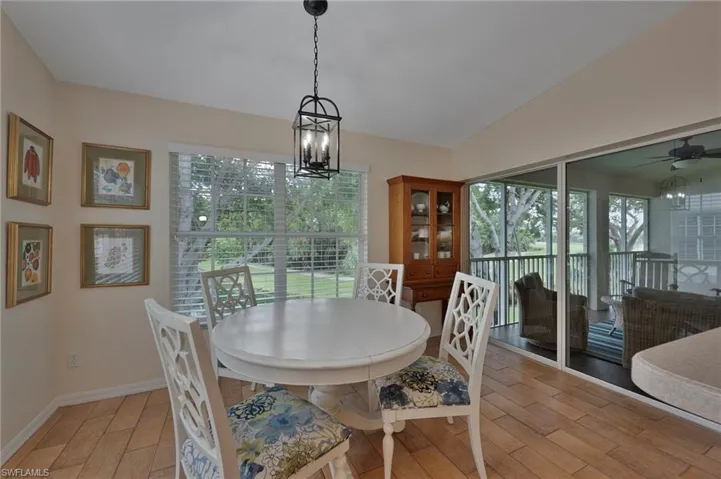 Dining space featuring plenty of natural light, light wood finished floors, a chandelier, and a ceiling fan