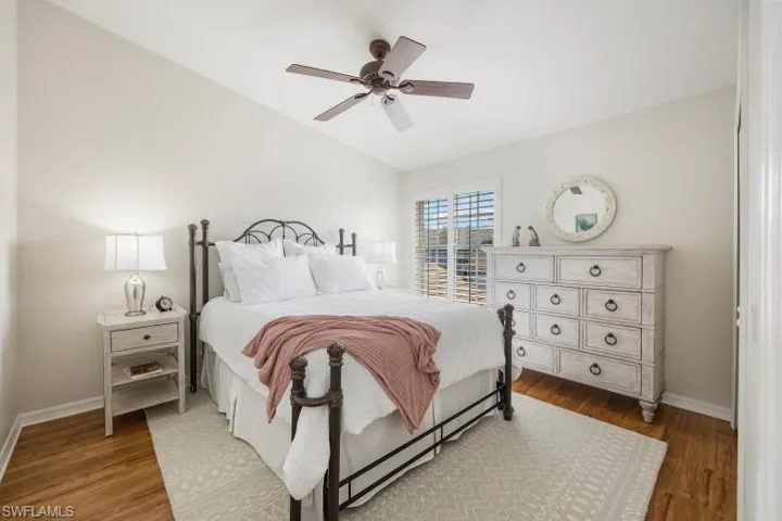 Bedroom with vaulted ceiling, wood finished floors, and a ceiling fan