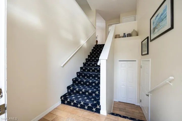 Staircase featuring tile patterned floors and baseboards