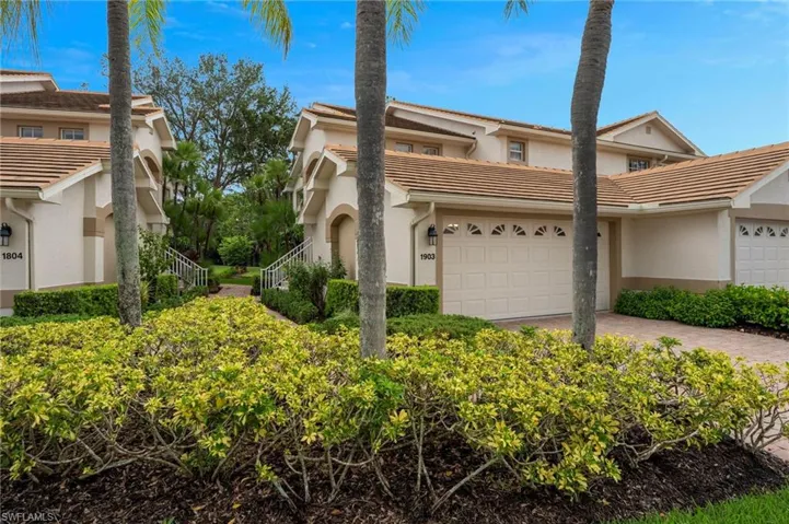 View of side of home with stucco siding, a tile roof, and decorative driveway