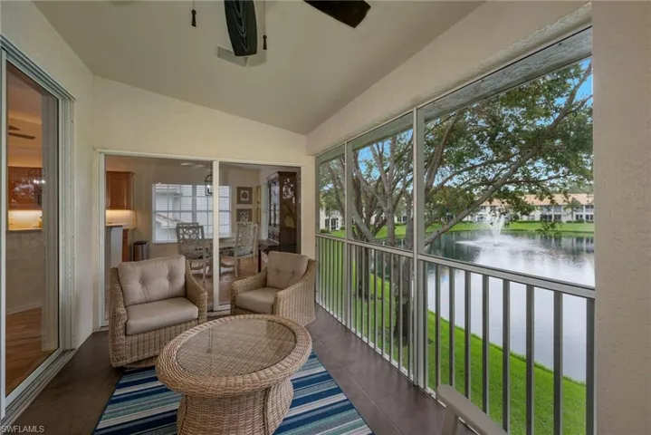 Sunroom / solarium with vaulted ceiling, a water view, a ceiling fan, and a balcony