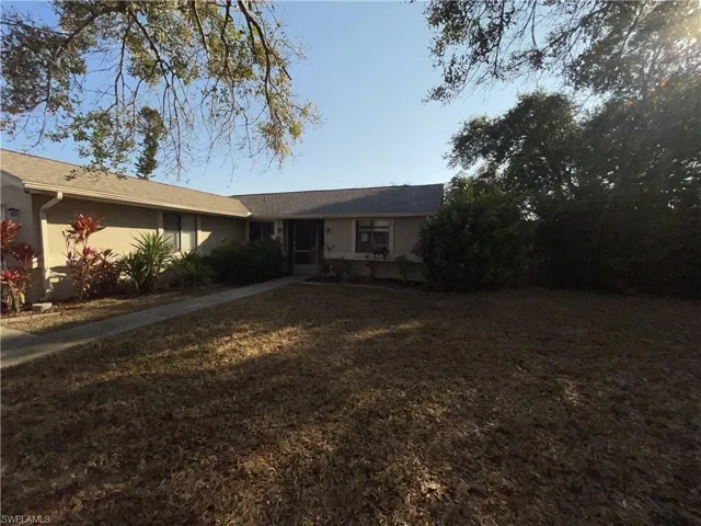 Ranch-style home with a front yard and stucco siding