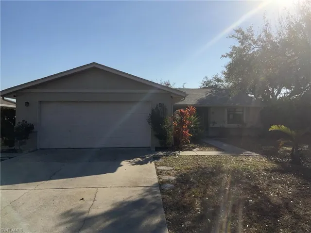 Single story home with driveway, an attached garage, and stucco siding